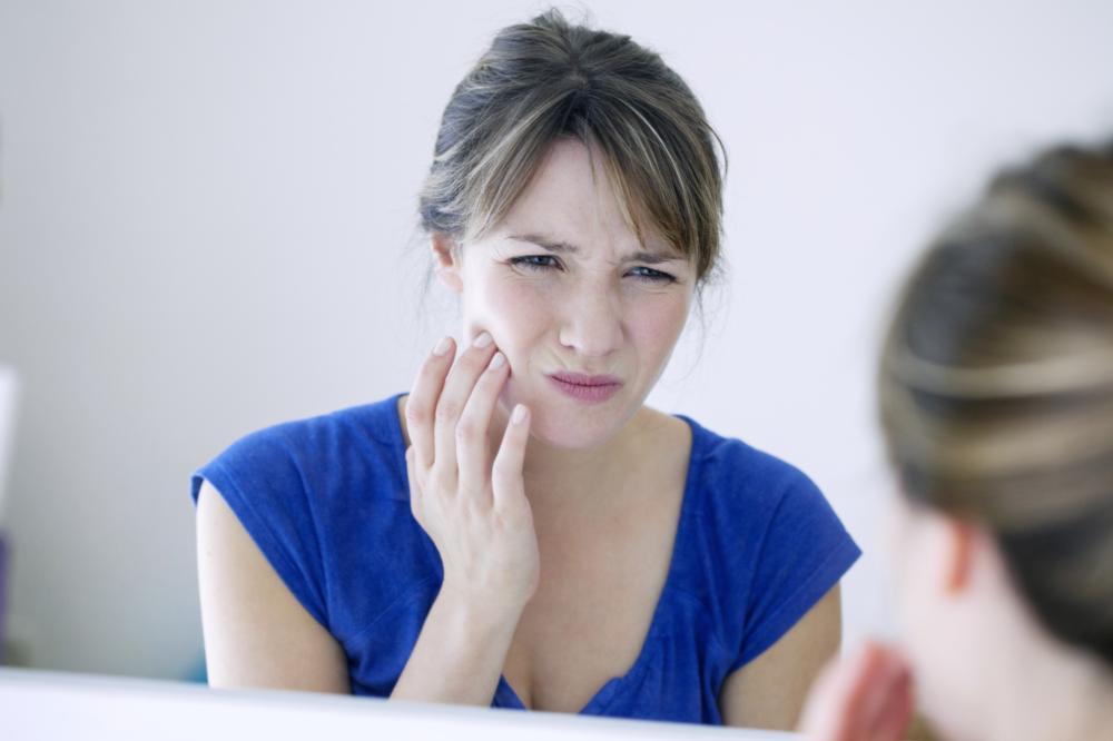 woman holding jaw from toothache
