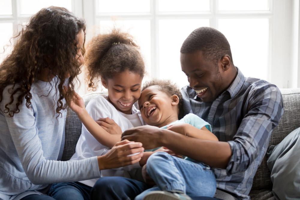 family of four smiling on couch