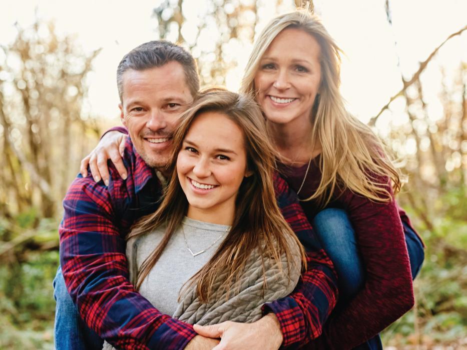 Father, mother and daughter smiling 